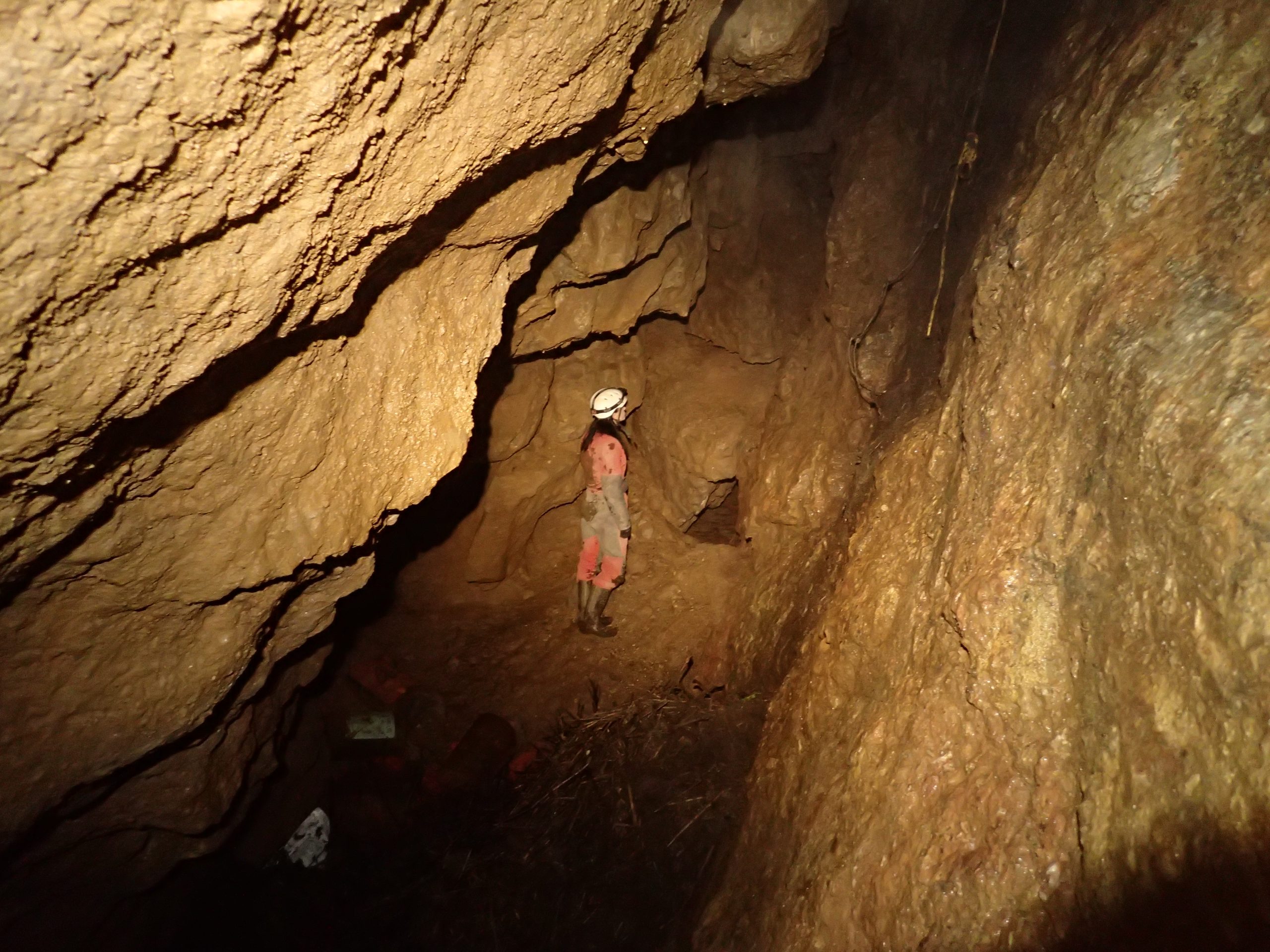 A caver exploring the passages of Charnel Shaft.