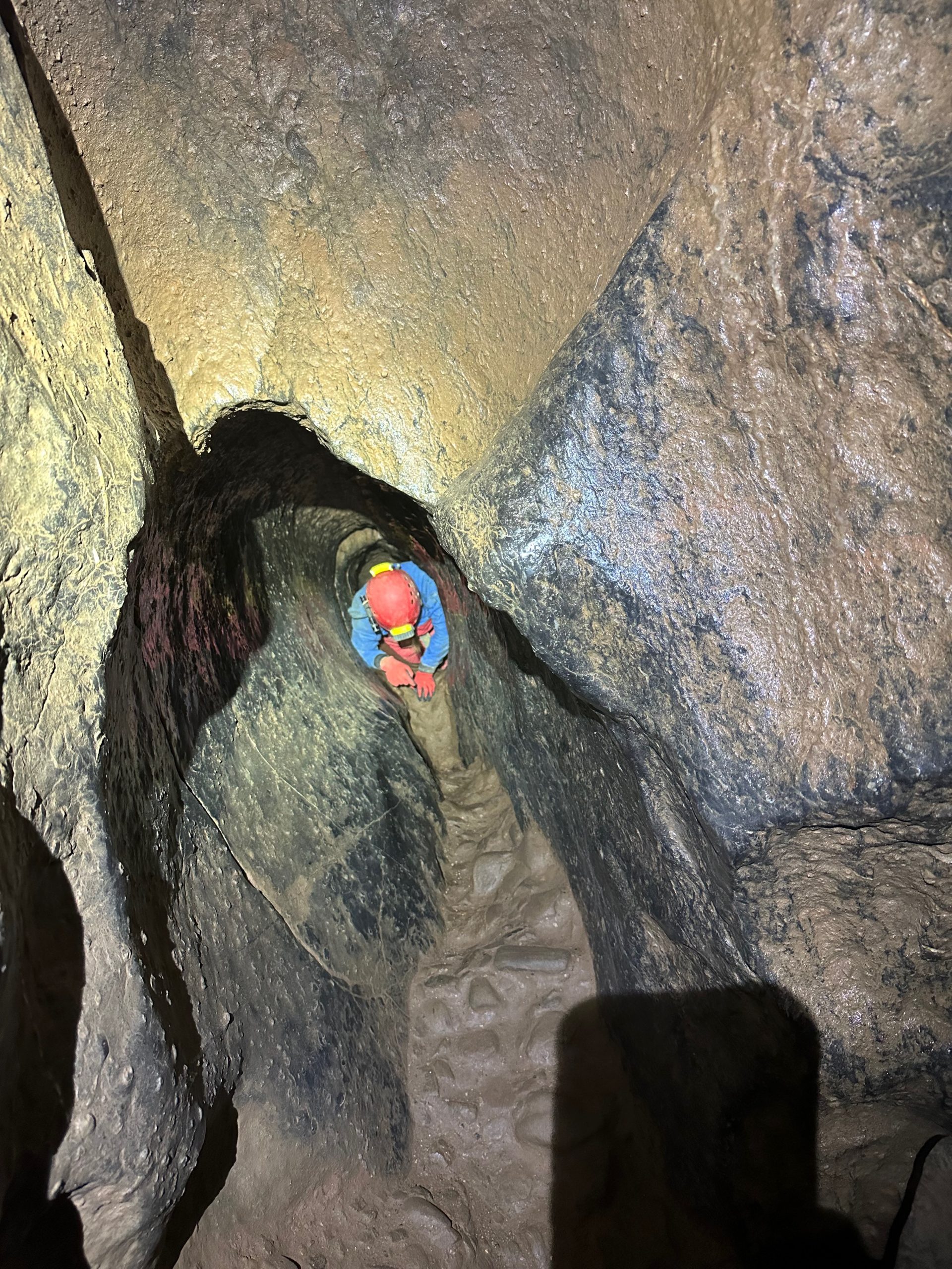 A caver in a narrow passage.