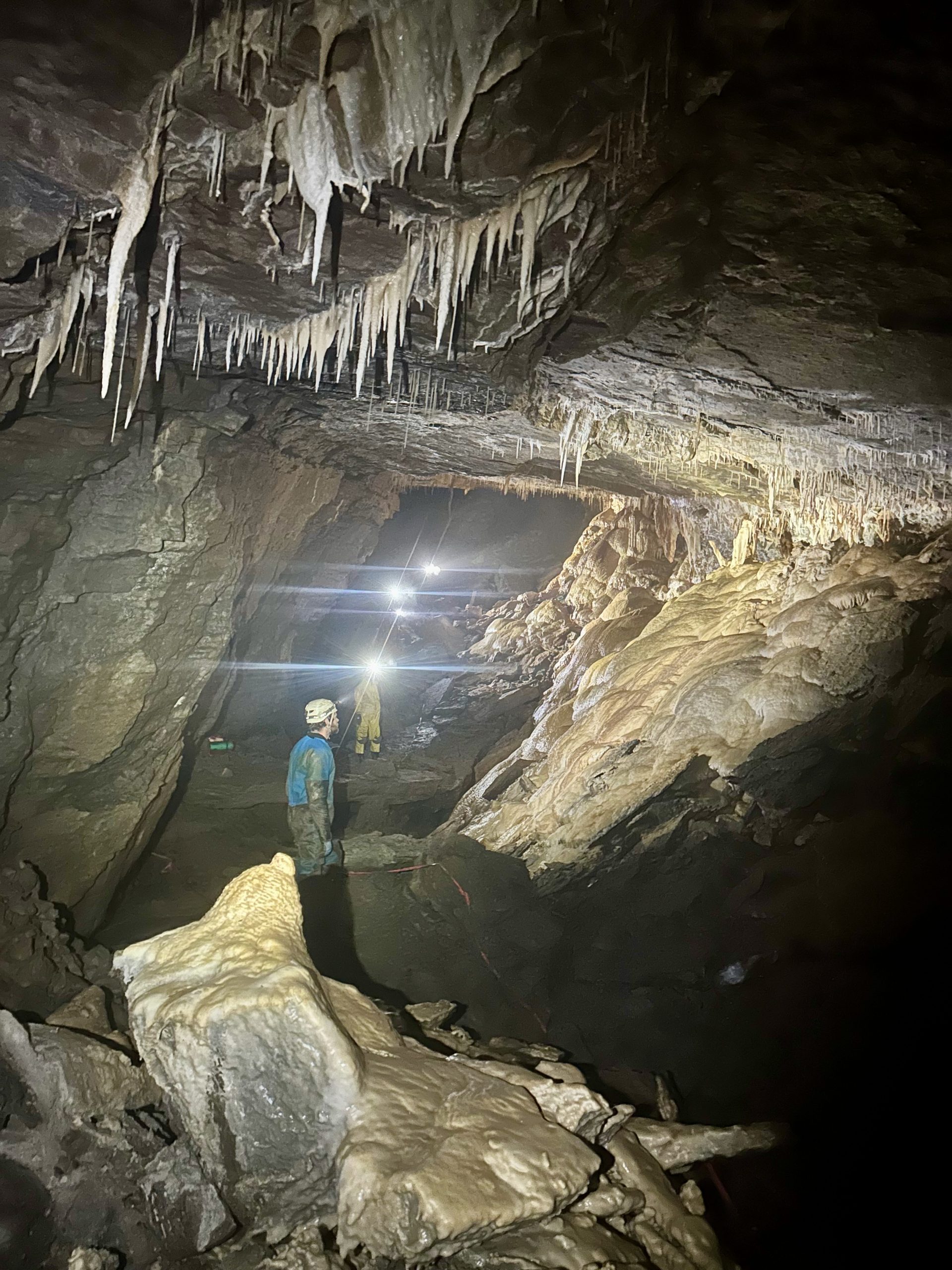 Cavers exploring a cave chamber.