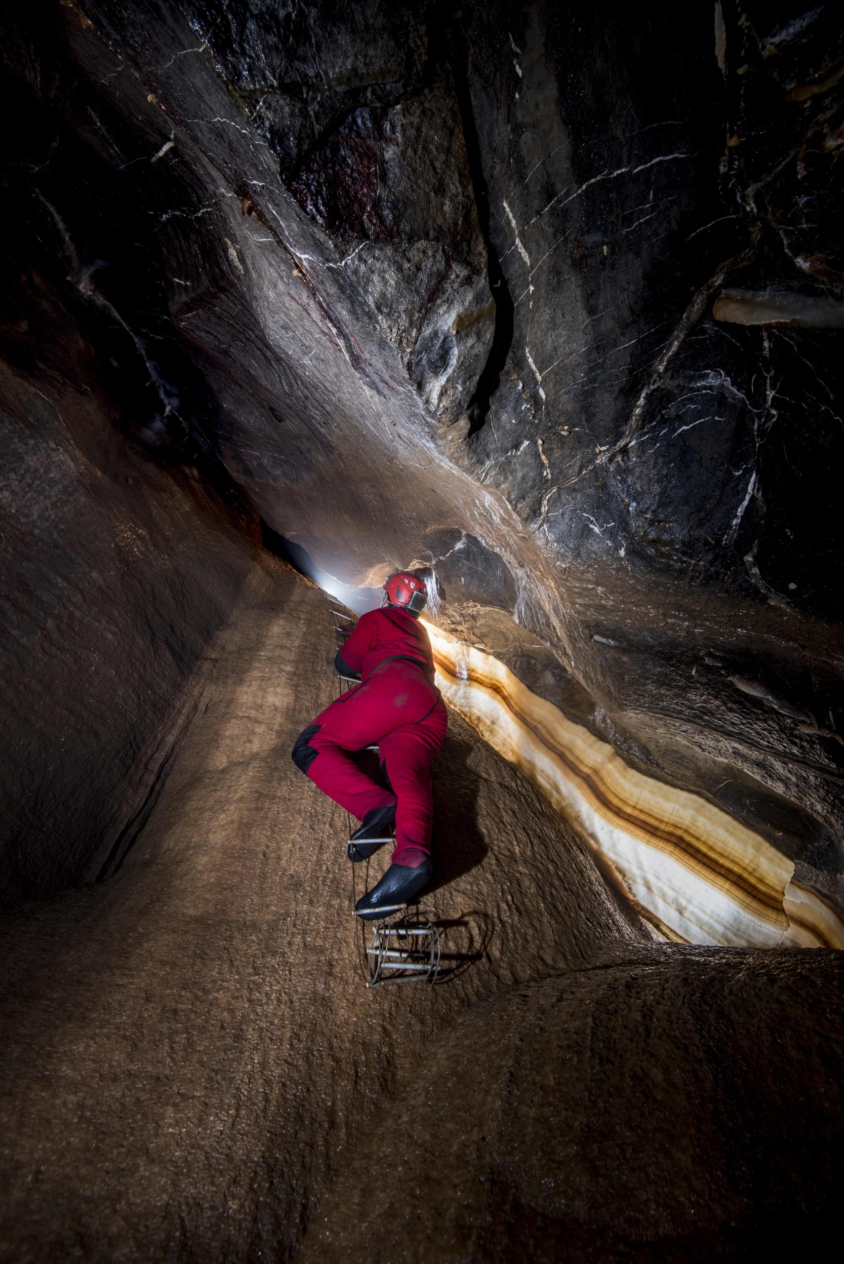 Caver on ladder at Curtain Climb