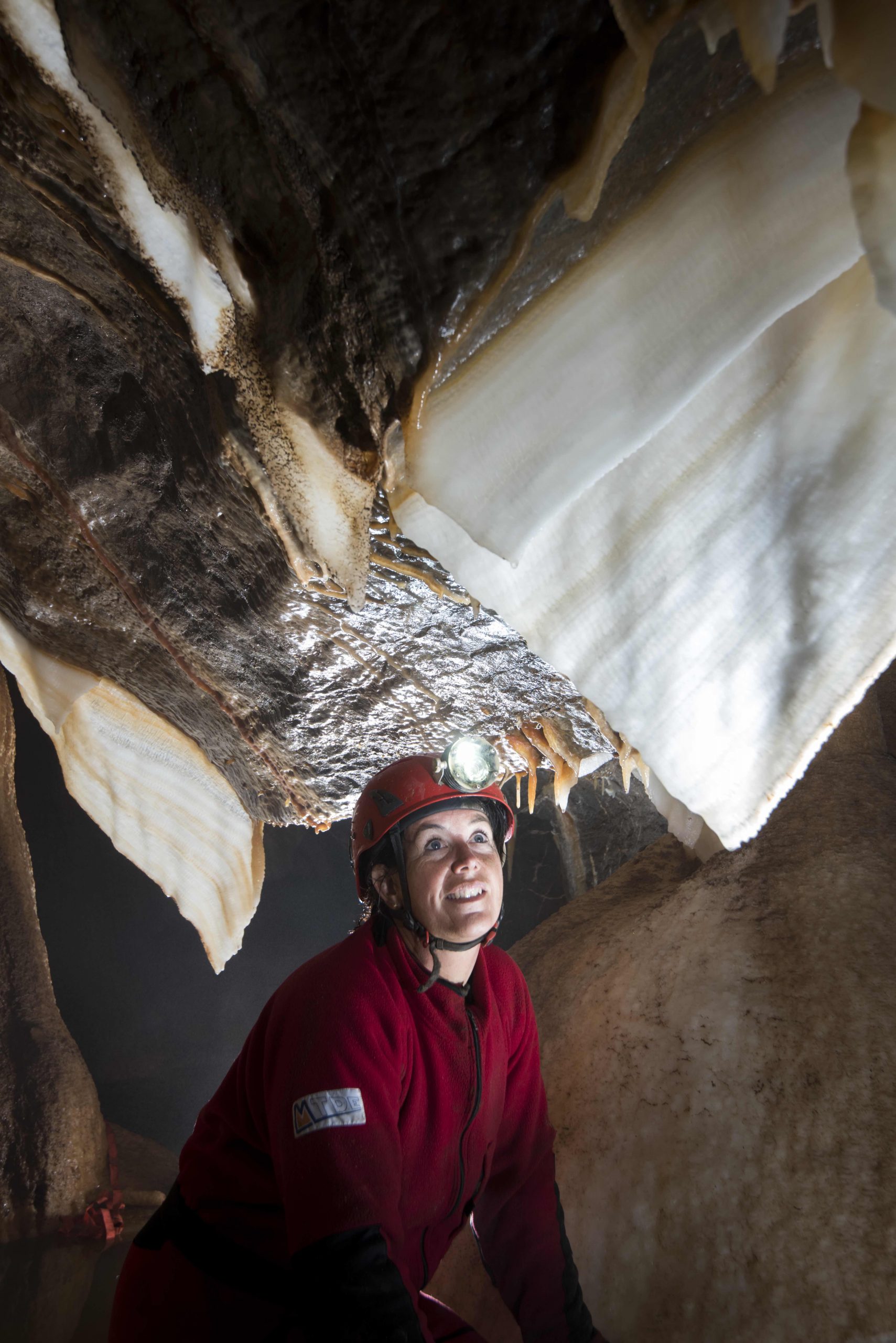 Caver illuminates stalactite curtain