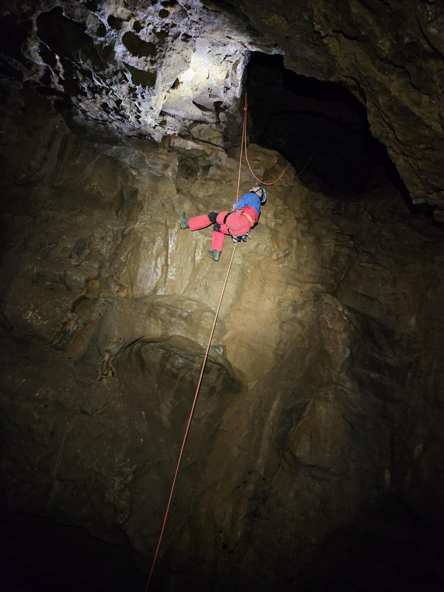 Cavers dangling on a rope