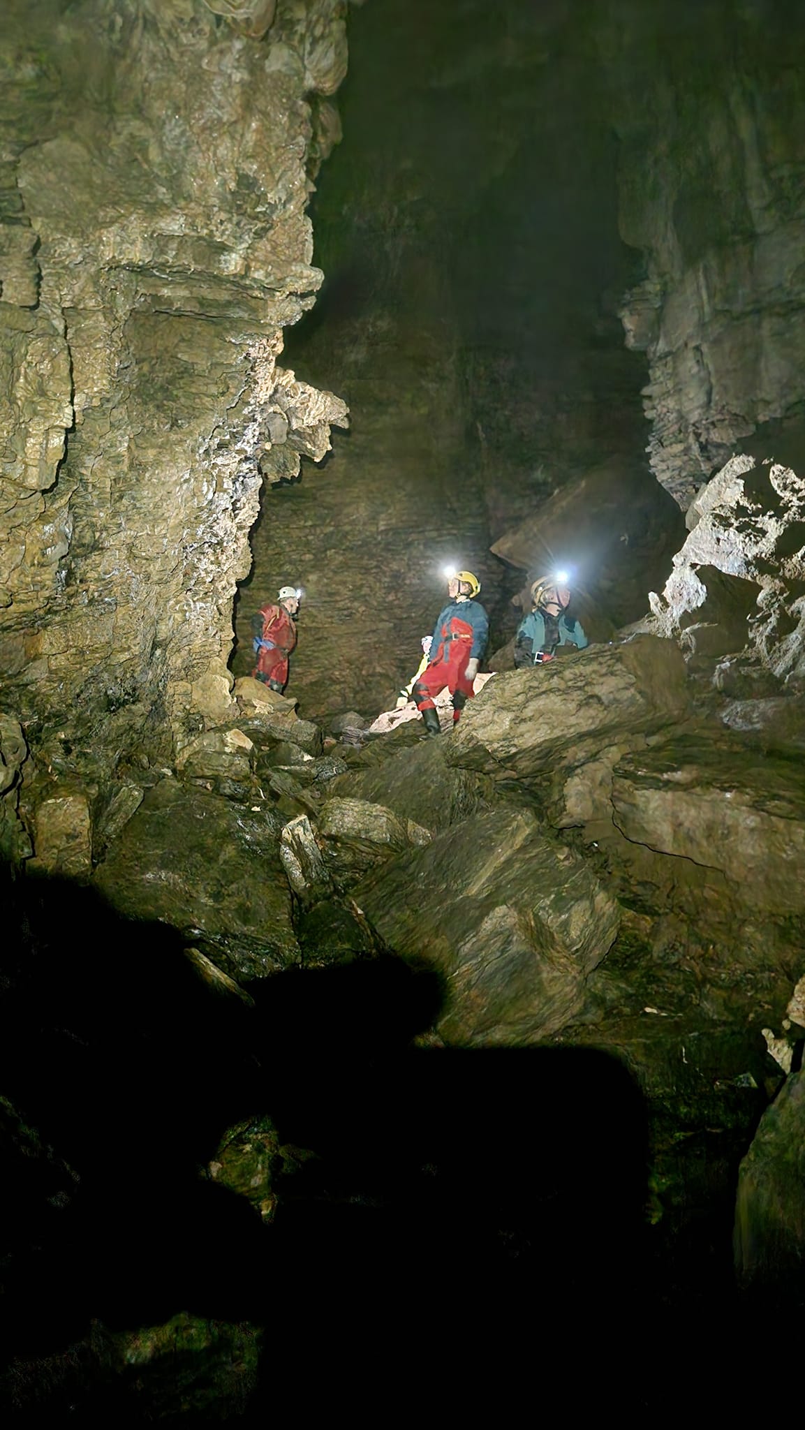 A caver with a headtorch in a dark cave